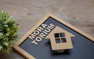 cardboard house on a clipboard that reads moratorium to reflect insurance moratoriums