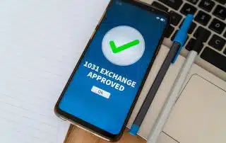 Smartphone displaying ‘1031 exchange approved’ to illustrate a successful real estate tax-deferred exchange.