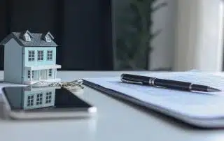 Rental agreement documents and house keys representing rental property ownership and insurance.